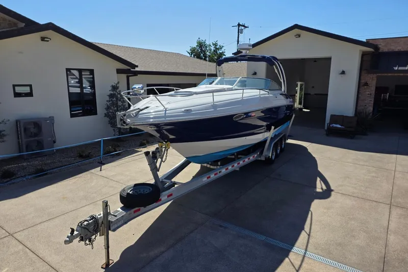 Slide: The Image of 2013 Crownline 325 SCR boat on trailer in driveway, sunny day. - 6