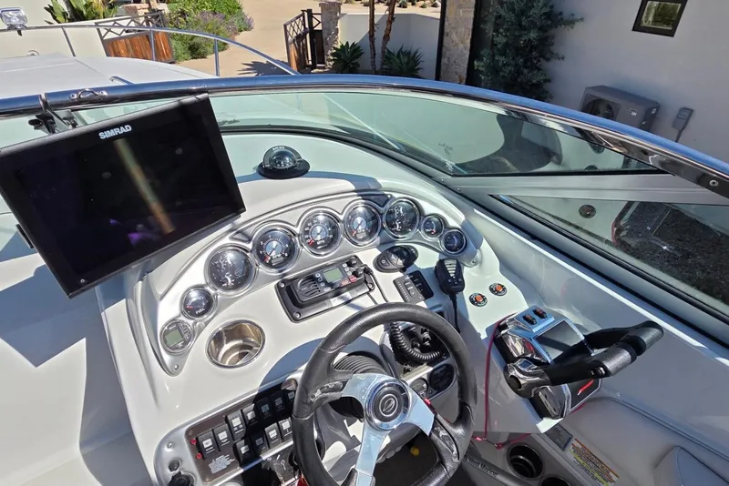 Slide: The Image of 2013 Crownline 325 SCR boat dashboard with steering wheel and navigation instruments. - 9