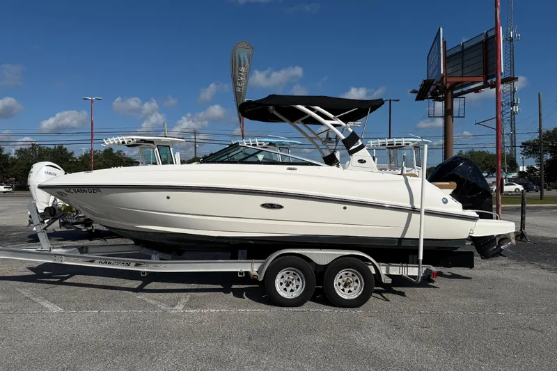 Slide: The Image of 2014 Sea Ray 240 Sundeck Outboard boat on trailer under clear blue sky. - 1