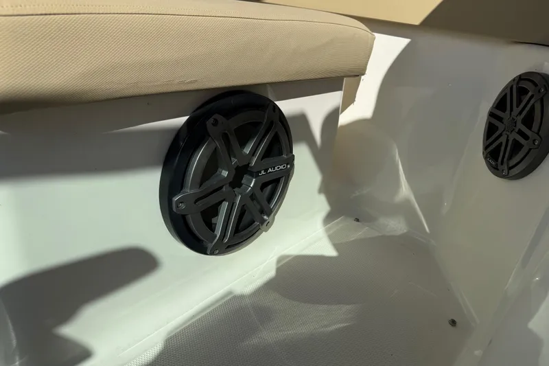 Slide: The Image of 2014 Sea Ray 240 Sundeck Outboard with JL Audio speakers and beige seating. - 16