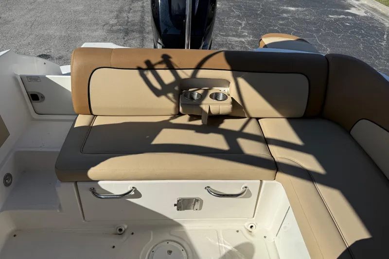 Slide: The Image of 2014 Sea Ray 240 Sundeck Outboard boat seating with cup holders, beige upholstery. - 17