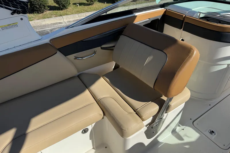 Slide: The Image of 2014 Sea Ray 240 Sundeck Outboard interior seating with tan upholstery. - 18