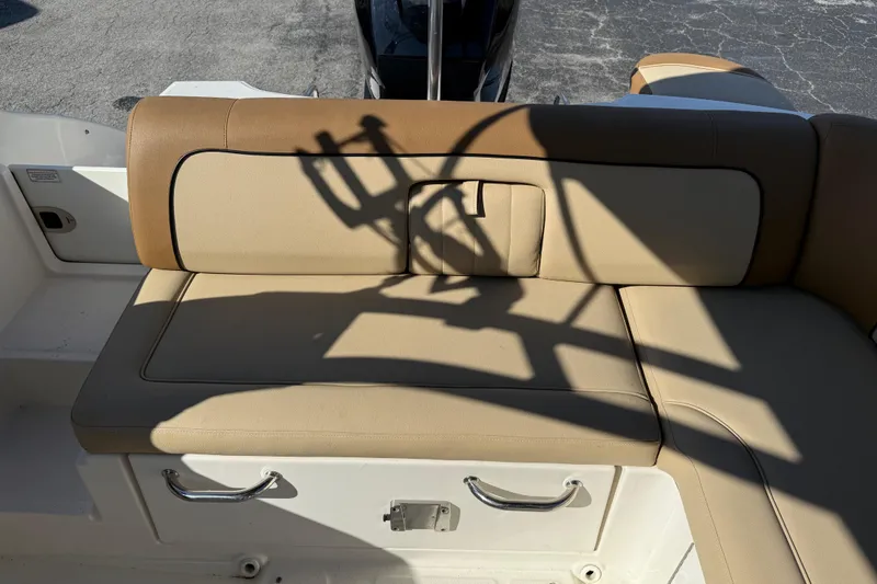 Slide: The Image of 2014 Sea Ray 240 Sundeck Outboard boat seat with tan upholstery and storage handles. - 19