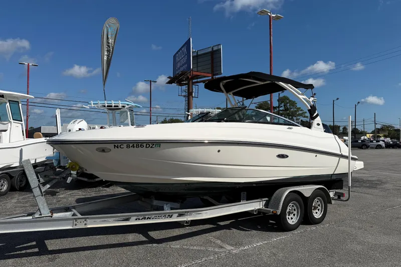Slide: The Image of 2014 Sea Ray 240 Sundeck Outboard on trailer under clear blue sky. - 2