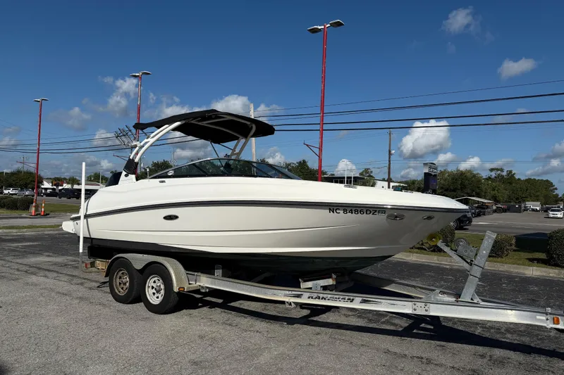 Slide: The Image of 2014 Sea Ray 240 Sundeck Outboard on trailer under clear blue sky. - 4