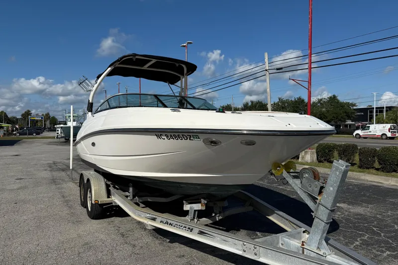 Slide: The Image of 2014 Sea Ray 240 Sundeck Outboard on trailer under clear blue sky. - 6