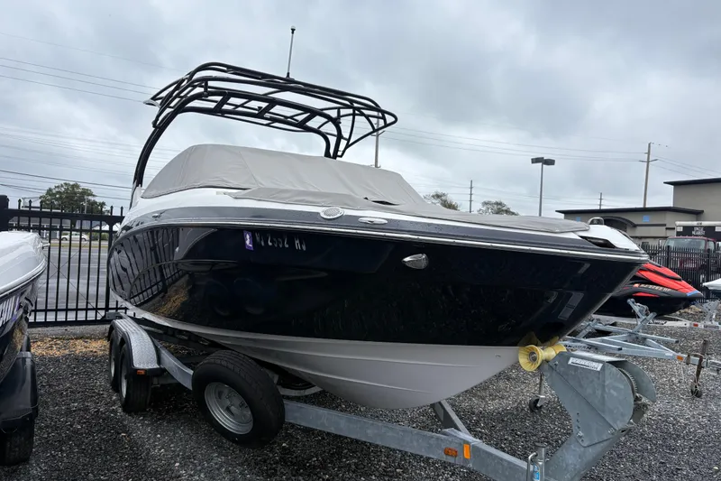 The Image of 2016 Yamaha Boats 242 Limited S on trailer, covered, parked outdoors. - 1