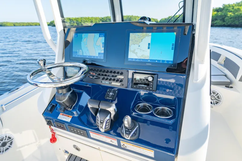 Slide: The Image of 2026 Cobia 245 Center Console boat dashboard with navigation screens and controls on the water. - 10