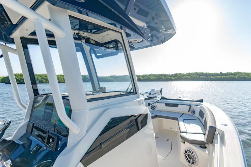 Slide: The Image of 2026 Cobia 245 Center Console boat on a sunny lake, featuring modern design and spacious seating. - 12