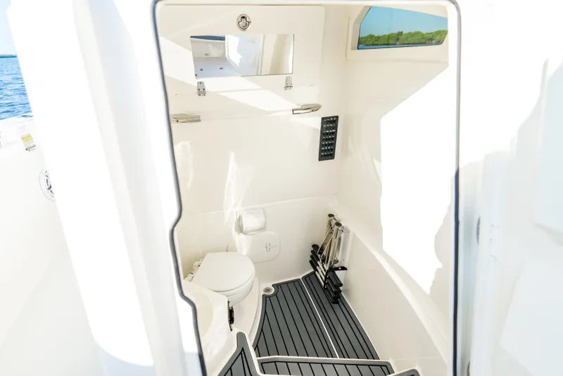 Slide: The Image of Interior of 2026 Cobia 245 Center Console boat, featuring a compact marine toilet. - 18