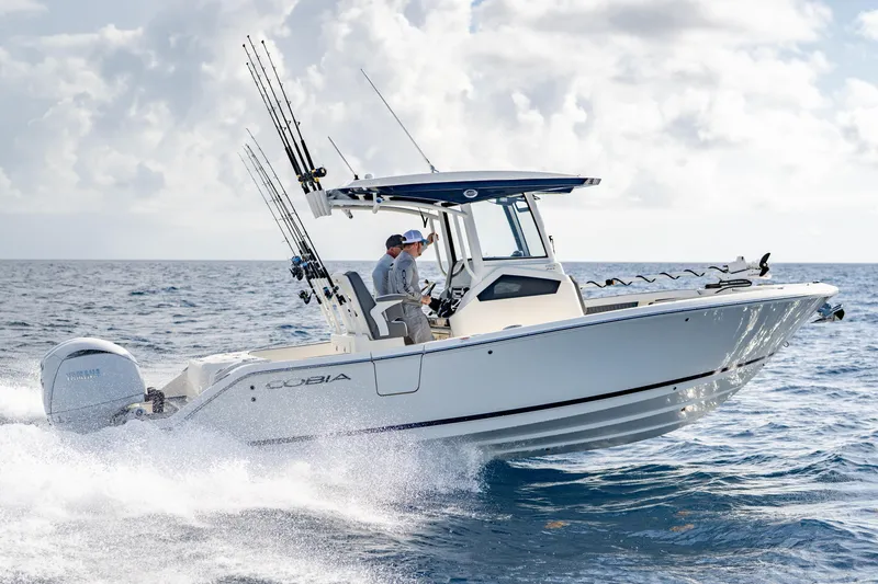 Slide: The Image of 2026 Cobia 245 Center Console boat on open ocean, two people fishing. - 3