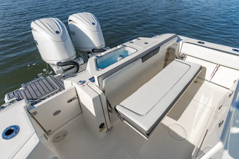 Slide: The Image of 2026 Cobia 245 Center Console boat with dual engines and seating, on calm water. - 6