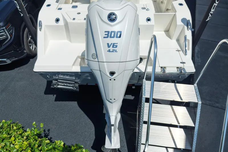 Slide: The Image of 2027 Cobia 245 Center Console with Yamaha 300 V6 engine, docked with metal stairs. - 8
