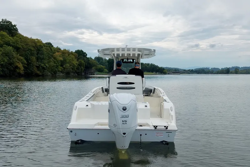Slide: The Image of 2027 Cobia 245 Center Console boat cruising on a serene lake. - 35