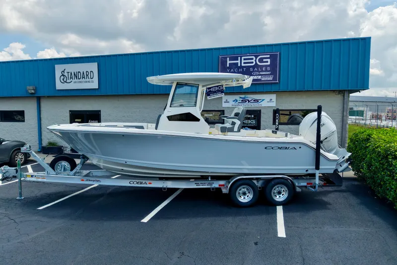 Slide: The Image of 2027 Cobia 245 Center Console boat on trailer outside yacht sales building. - 1