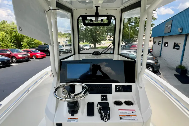 Slide: The Image of 2027 Cobia 245 Center Console boat dashboard with steering wheel and navigation display. - 14