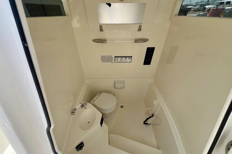 Slide: The Image of Interior of 2027 Cobia 245 Center Console boat, featuring compact marine toilet and sink. - 18