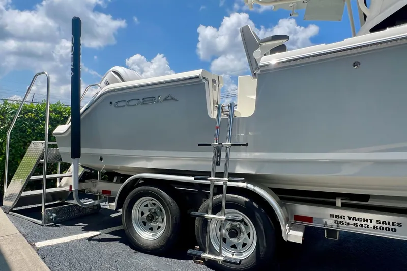 Slide: The Image of 2027 Cobia 245 Center Console boat on trailer under a sunny sky. - 7