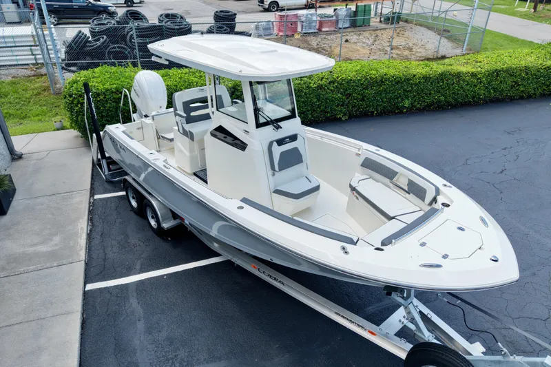Slide: The Image of 2027 Cobia 245 Center Console boat on trailer, parked in lot, side view. - 23