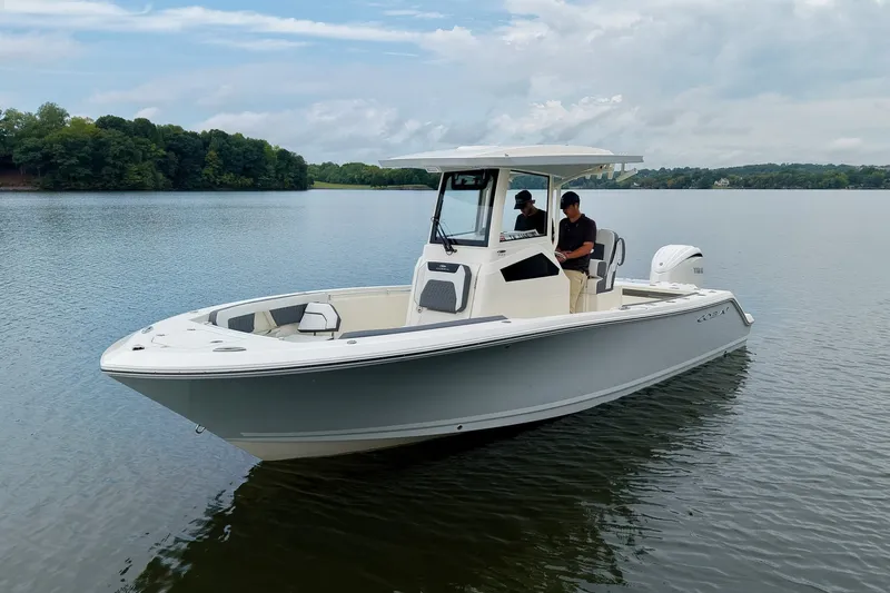 Slide: The Image of 2027 Cobia 245 Center Console boat on a calm lake with two people onboard. - 37