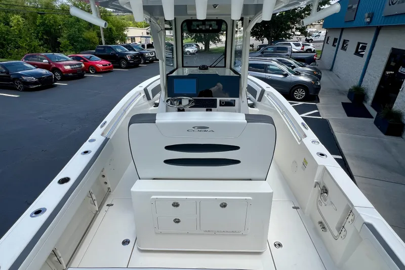 Slide: The Image of 2027 Cobia 245 Center Console boat interior with helm and seating in a parking lot. - 25