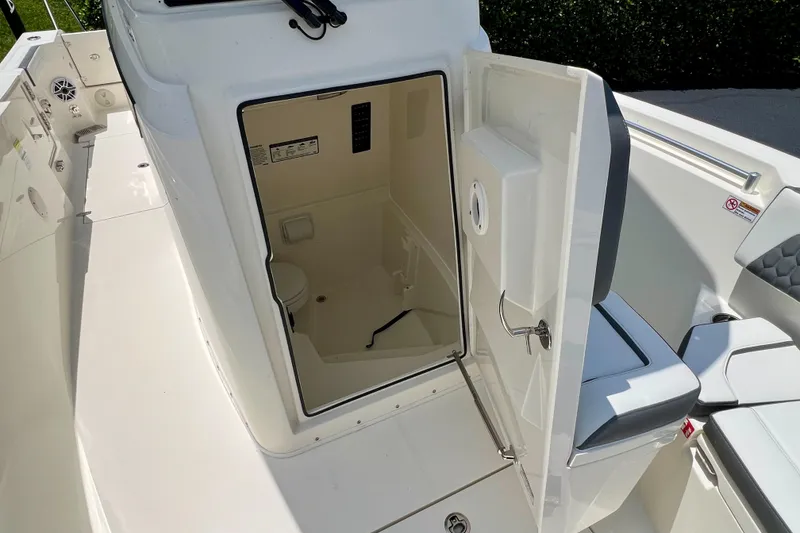 Slide: The Image of 2027 Cobia 245 Center Console boat with open cabin door revealing interior space. - 17