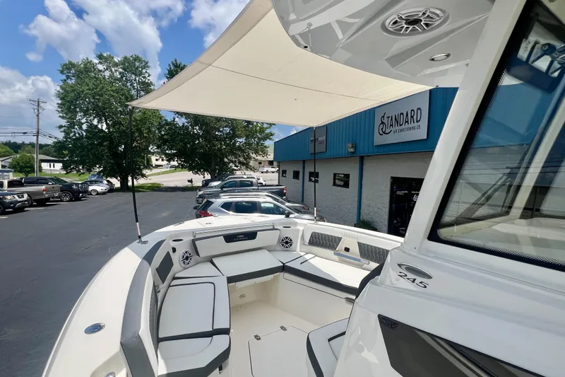 Slide: The Image of 2027 Cobia 245 Center Console boat with seating, parked outside a blue building. - 5