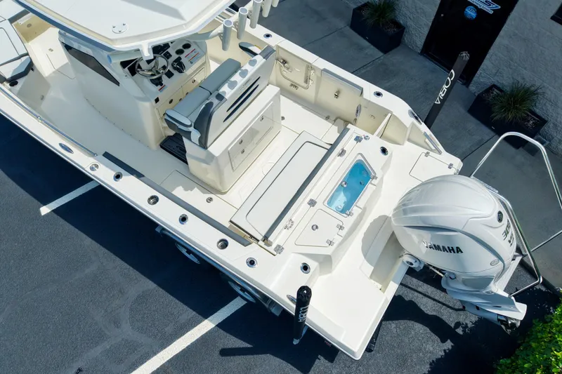 Slide: The Image of 2027 Cobia 245 Center Console boat with Yamaha engine, aerial view of deck and seating. - 22