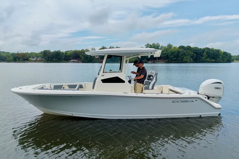 Slide: The Image of 2027 Cobia 245 Center Console boat on calm lake with two people onboard. - 38
