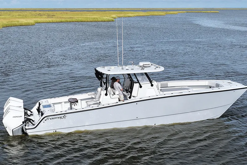 Slide: The Image of 2022 Freeman 37VH boat cruising on calm waters with scenic marshland backdrop. - 0