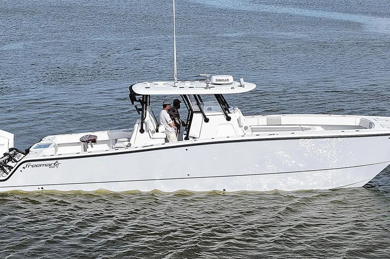 Slide: The Image of 2022 Freeman 37VH boat on calm water, featuring sleek white design and modern equipment. - 1