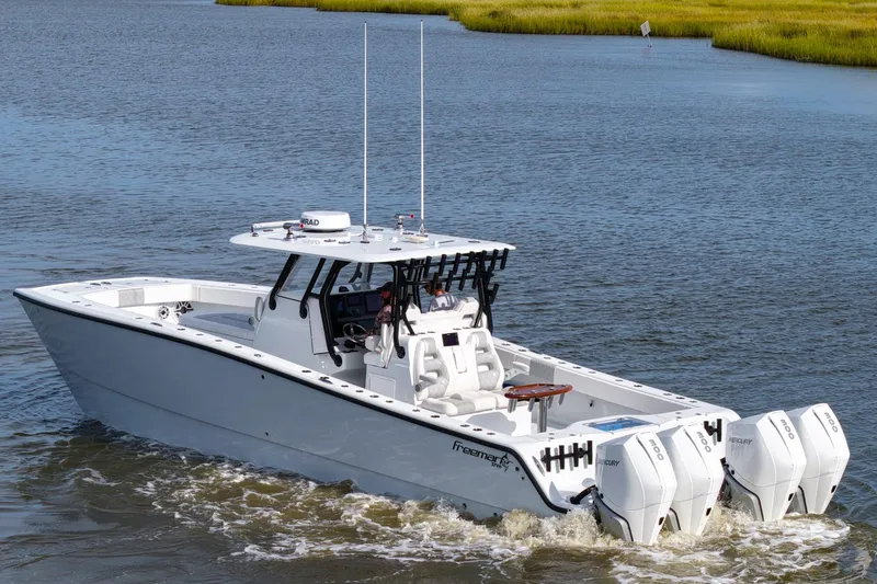 Slide: The Image of 2022 Freeman 37VH boat cruising on a calm river with triple Mercury engines. - 13