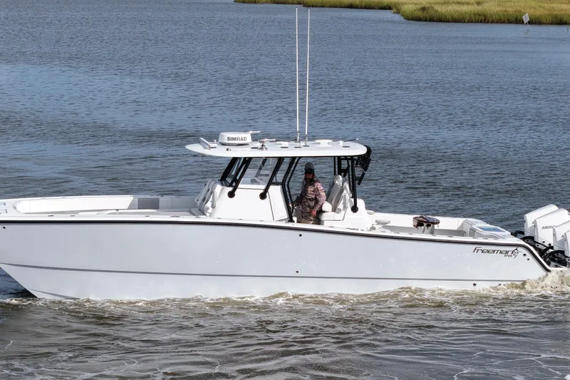 Slide: The Image of 2022 Freeman 37VH boat cruising on calm waters with a person at the helm. - 15