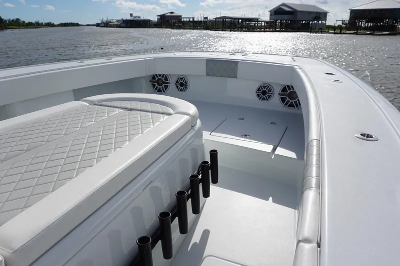 Slide: The Image of 2022 Freeman 37VH boat interior with cushioned seating and rod holders on a sunny day. - 19