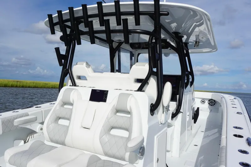 Slide: The Image of 2022 Freeman 37VH boat with sleek white seating and black rod holders on a sunny day. - 34