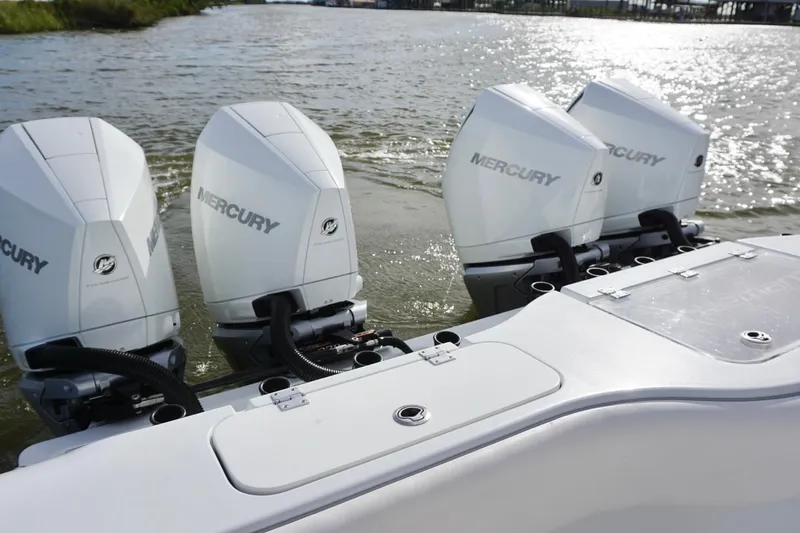 Slide: The Image of Four Mercury outboard engines on a 2022 Freeman 37VH boat in water. - 35