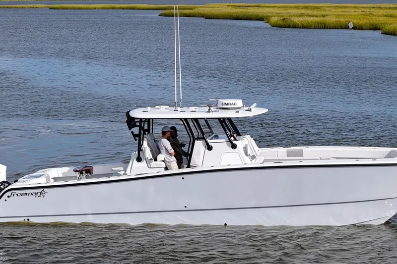 Slide: The Image of 2022 Freeman 37VH boat cruising on calm waters with two people onboard. - 6