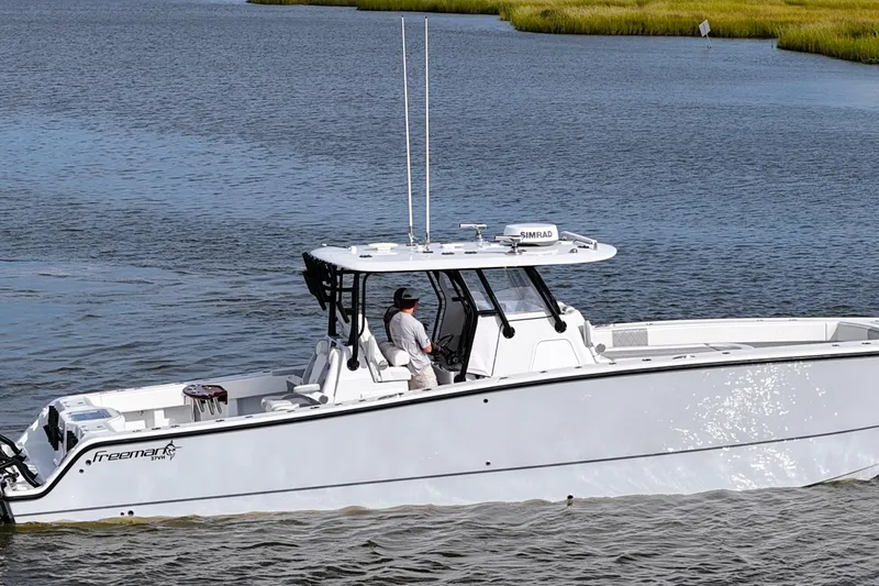 Slide: The Image of 2022 Freeman 37VH boat cruising on a calm river with lush green banks. - 7