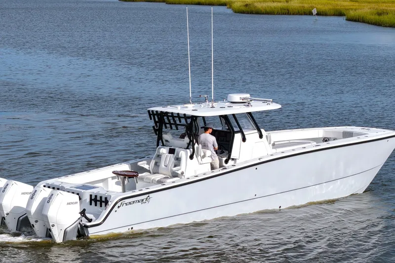 Slide: The Image of 2022 Freeman 37VH boat cruising on a calm waterway, featuring dual Mercury engines. - 8