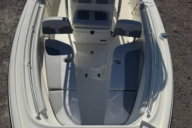 Slide: The Image of 2021 Mako 214 Center Console boat interior with cushioned seating and storage. - 12