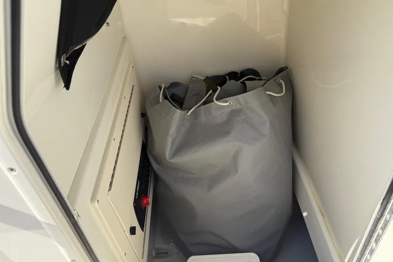 Slide: The Image of Storage compartment in a 2021 Mako 214 Center Console boat with a large gray bag. - 18