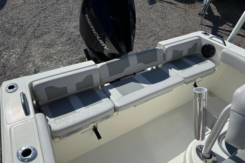 Slide: The Image of 2021 Mako 214 Center Console boat interior with cushioned seating and Mercury engine. - 19