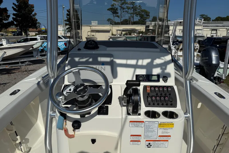 Slide: The Image of 2021 Mako 214 Center Console boat dashboard with steering wheel and control panel. - 22