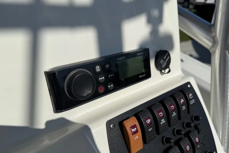 Slide: The Image of Control panel of 2021 Mako 214 Center Console boat with audio system and switches. - 25