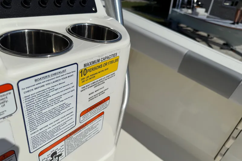 Slide: The Image of 2021 Mako 214 Center Console boat capacity label and cup holders. - 27