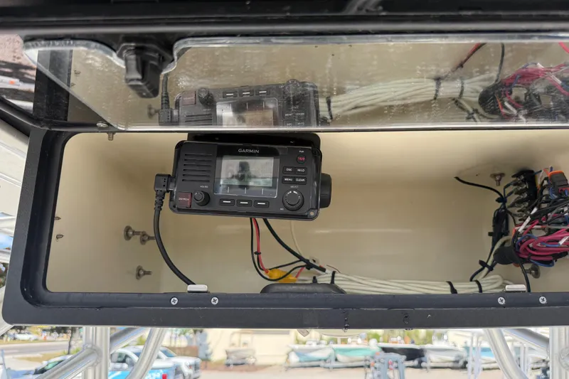 Slide: The Image of 2021 Mako 214 Center Console with Garmin marine radio and wiring inside storage compartment. - 28
