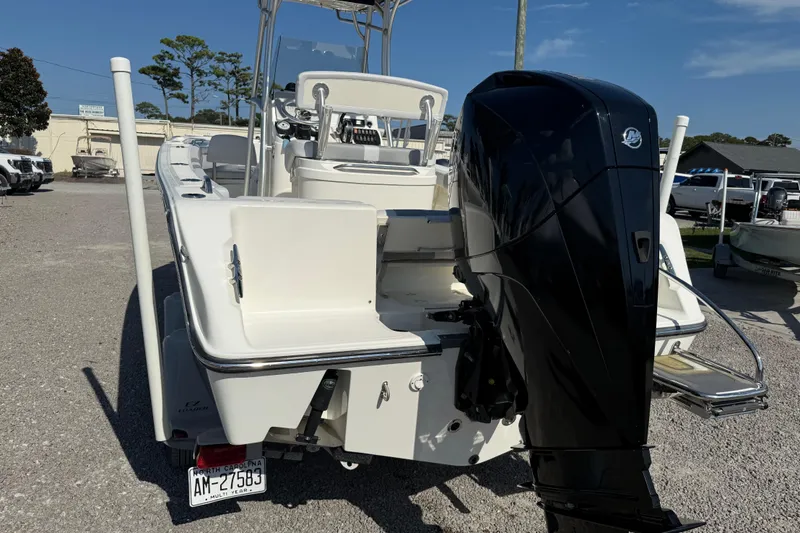 Slide: The Image of 2021 Mako 214 Center Console boat with powerful outboard motor, parked on gravel lot. - 7