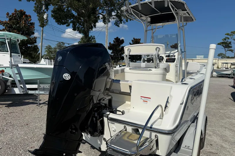 Slide: The Image of 2021 Mako 214 Center Console boat with powerful outboard motor, parked outdoors. - 9