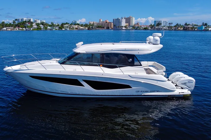The Image of 2022 Regal 42 XO yacht on calm blue water, cityscape in background. - 0