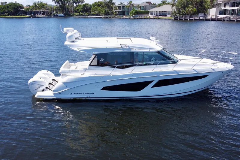 Slide: The Image of 2022 Regal 42 XO yacht on calm water, showcasing sleek design and powerful engines. - 3
